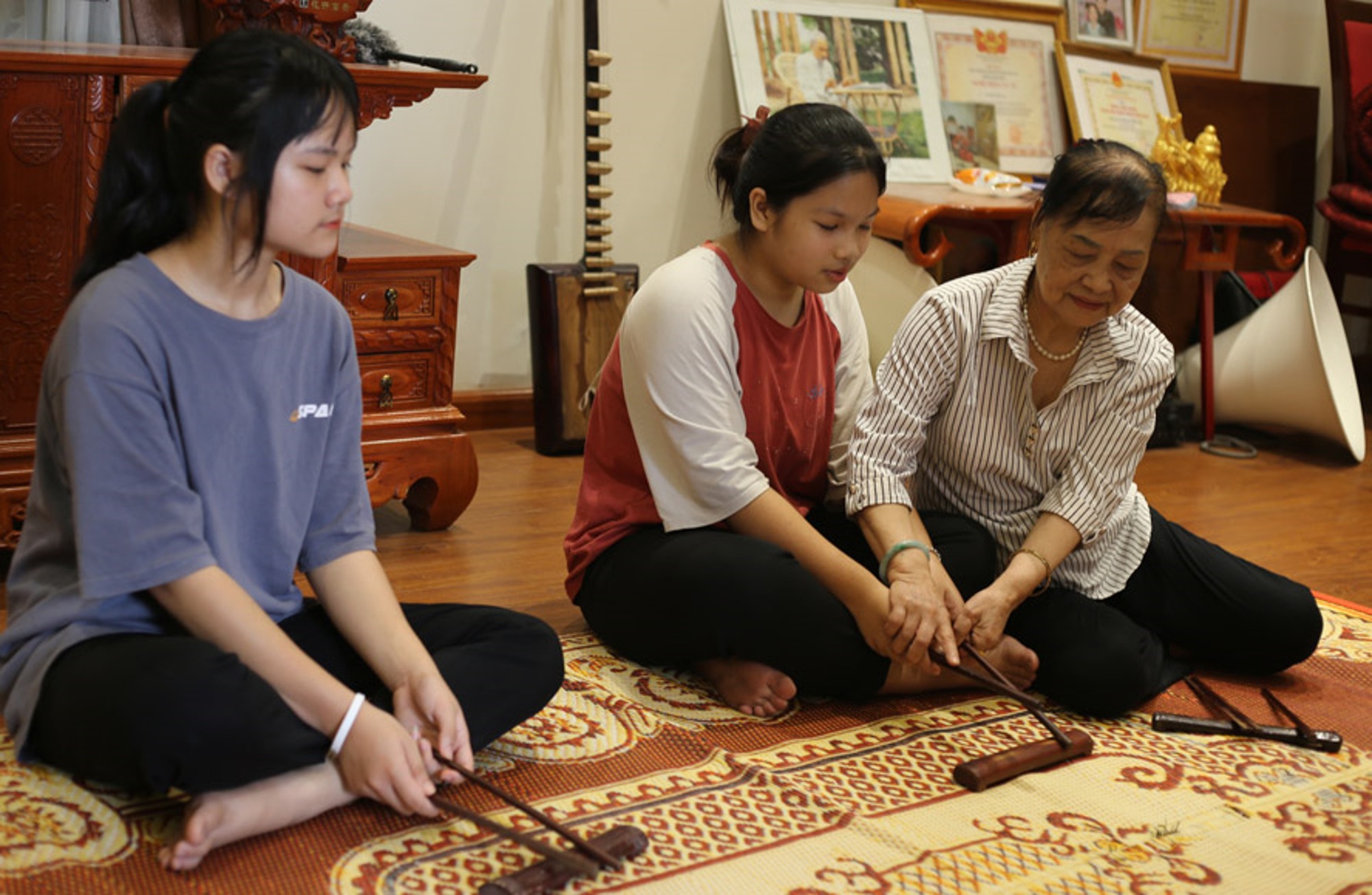 Nghệ nhân Nguyễn Thị Tam hướng dẫn các học viên trẻ kỹ thuật giữ nhịp phách.