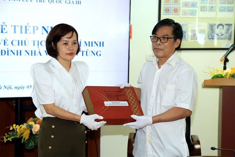 Giám đốc Trung tâm Lưu trữ Quốc gia III Trần Việt Hoa tiếp nhận các tài liệu của nhà văn Sơn Tùng từ ông Bùi Sơn Định (con trai cố nhà văn). Ảnh: HL