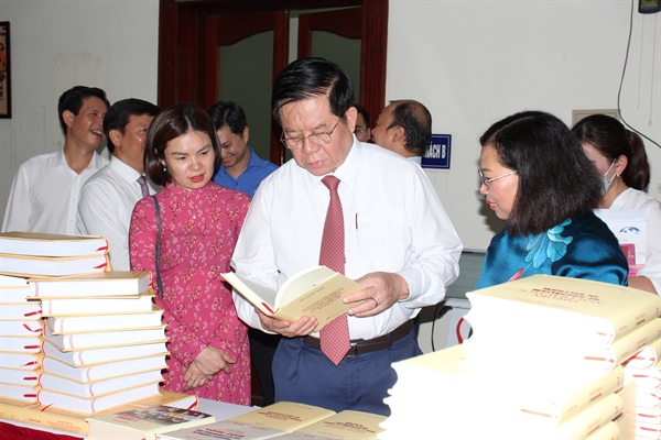 Trưởng ban Tuyên giáo Trung ương Nguyễn Trọng Nghĩa và các đại biểu tham khảo các ấn bản cuốn sách của Tổng Bí thư.