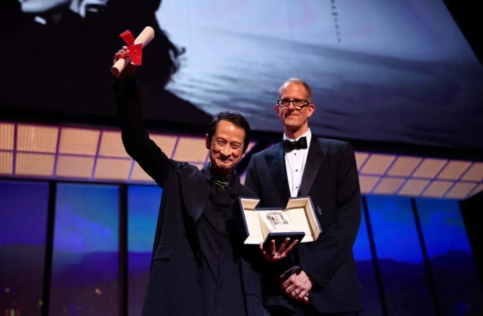 Trần Anh Hùng (trái) nhận giải Đạo diễn xuất sắc từ Peter Docter, đạo diễn, giám đốc sáng tạo hãng Pixar. Ảnh: AFP