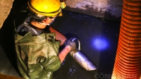 Công nhân môi trường ngâm mình dưới nước cống hút bùn 