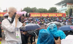 Hình ảnh phóng viên tác nghiệp dưới mưa tại lễ Kỷ niệm 70 năm Chiến thắng Điện Biên Phủ