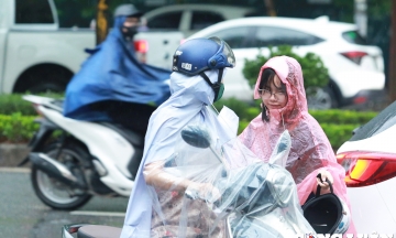 Phụ huynh 'đội mưa' đưa con đi thi môn cuối của kỳ thi lớp 10 công lập Hà Nội